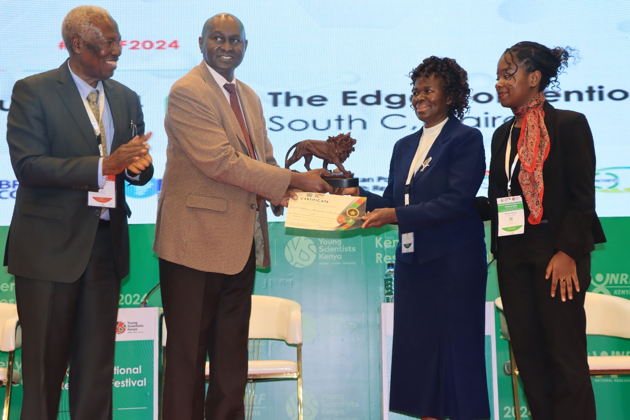 Prof. Mary Abukutsa-Onyango (second right) receives her award from the Kenya National Research Fund CEO, Prof. Dickson Andala as Prof Ratemo Michieka (left) looks on.