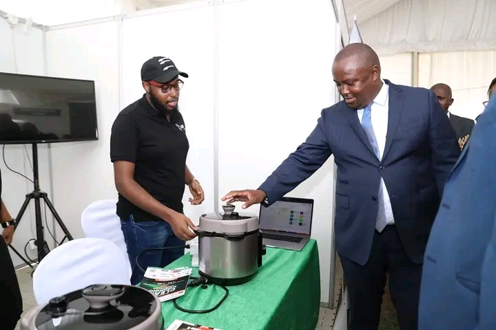 Exhibitors at the 5th edition of the clean cooking week expo explaining to the PS for Energy Anthony Wachira how their clean cooking innovations work. 