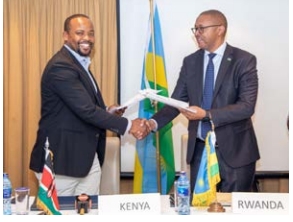 Lands PS Generali Nixon Korir (Left) and the Head  of the Rwandan delegation First Counsellor Donne  Besigye exchange copies of the report during a meeting in Nairobi.