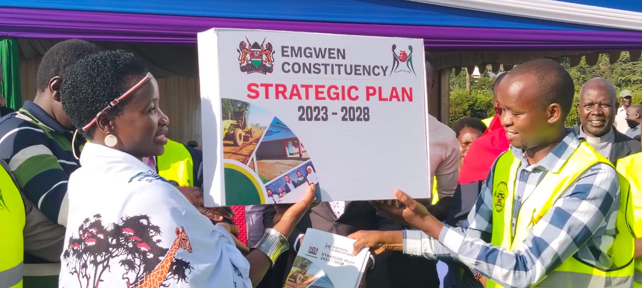 PS for the State Department of Micro Small and Medium Enterprises (MSMEs) Development, Susan Mang’eni and area MP Josses Lelmengit display the Emgwen Constituency Strategic Plan 2023_2028 after the launch at Eliud Kipchoge Showground in Kapsabet.