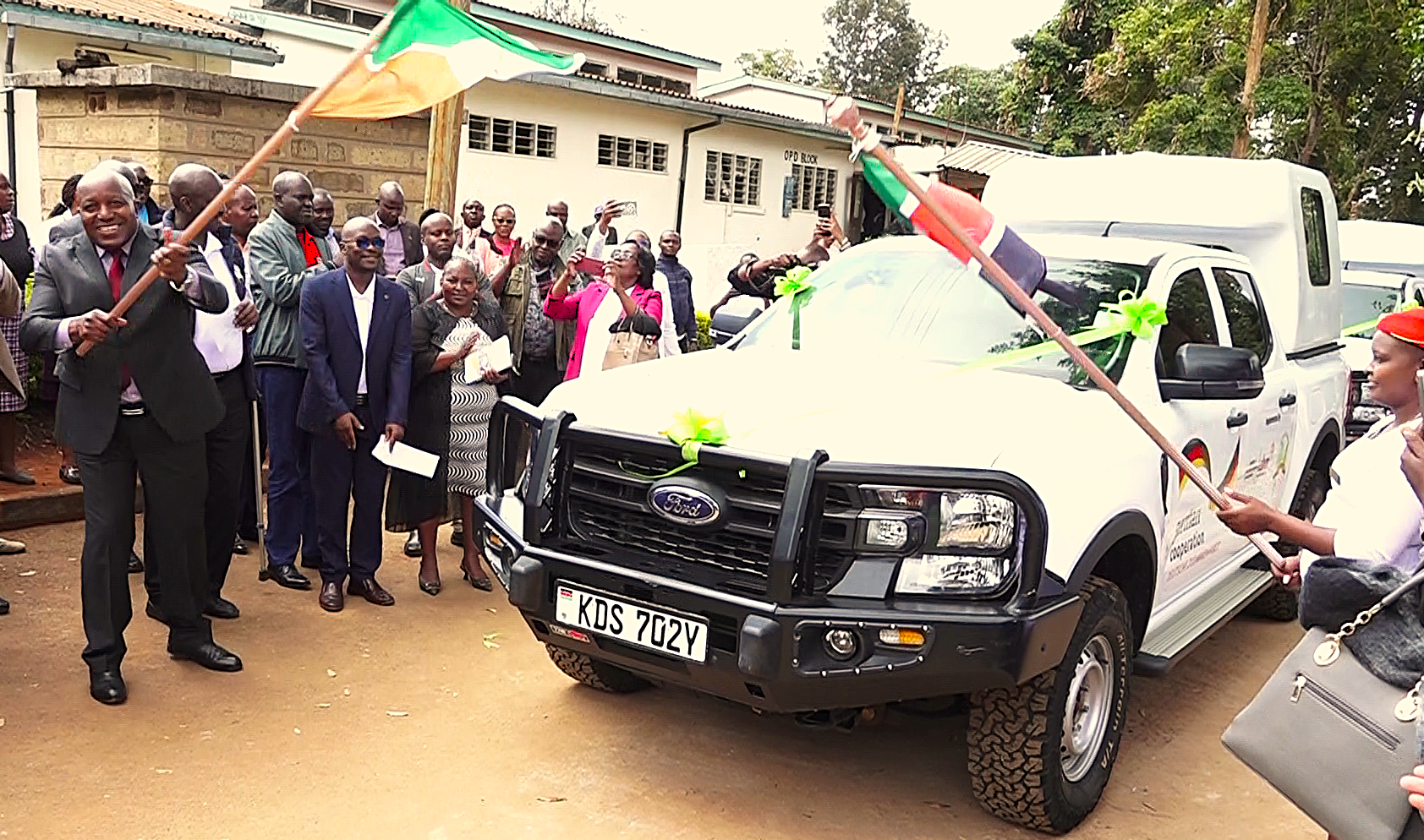 Embu Deputy Governor Kinyua Mugo (left) flags off two double cab pickups donated to the County by German Cooperation for the new rehabilitation center at Runyenjes Level Four Hospital.
