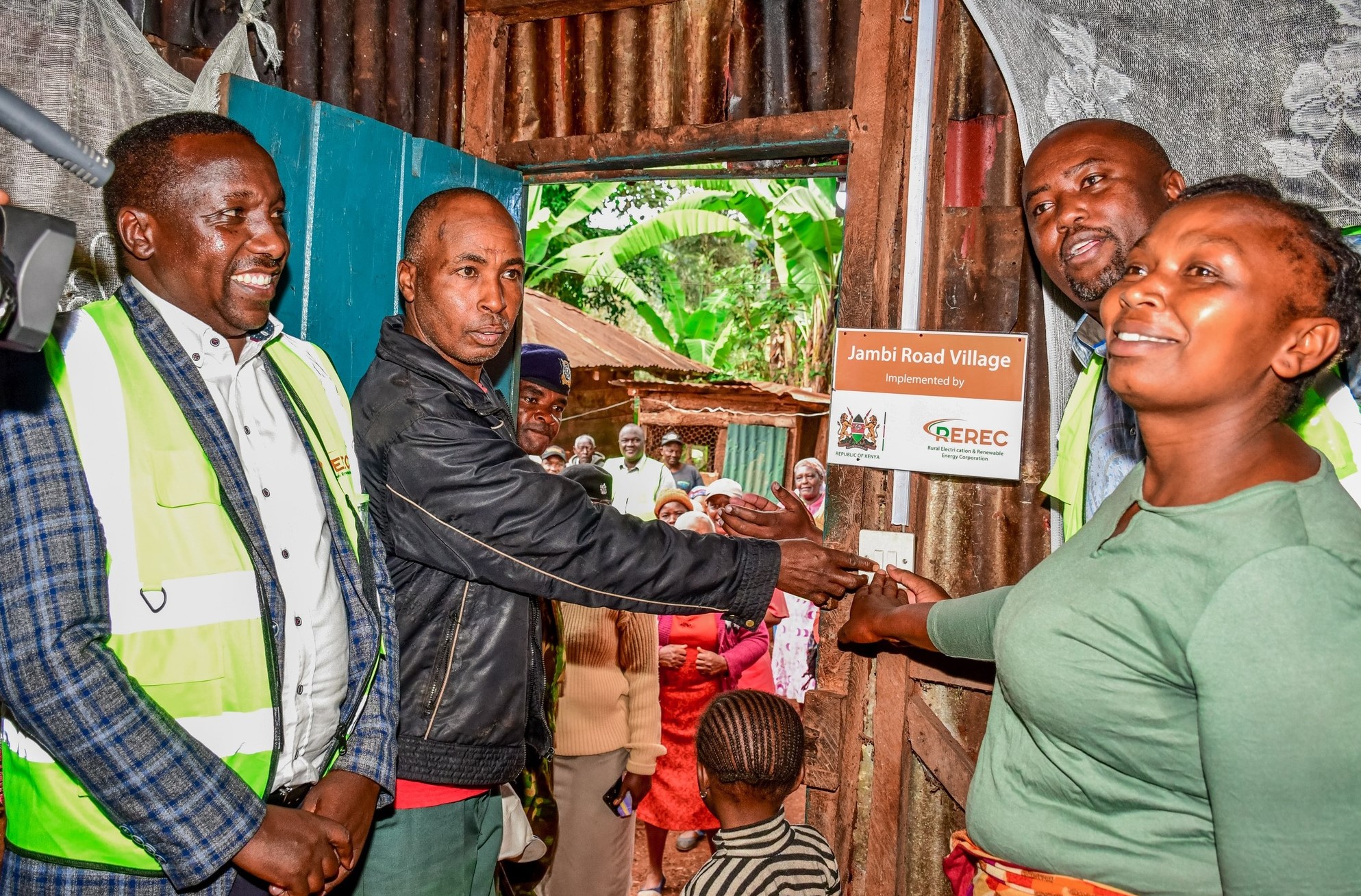 Principal Secretary for Energy Alex Wachira helps a family to switch on light. The household is one of the beneficiaries of power connection in Kangema constituency.