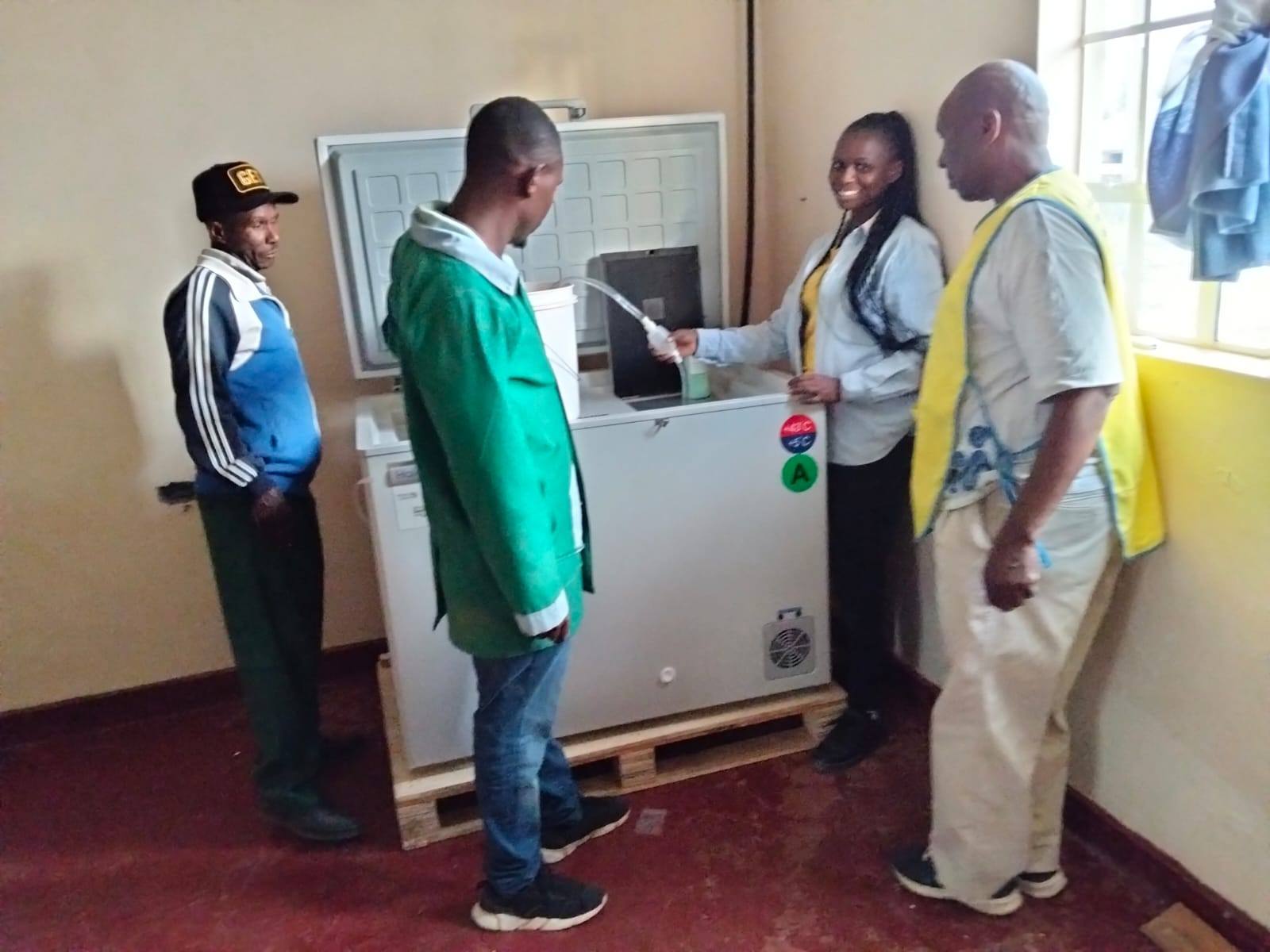 Biomedical engineers from the County Government of Nakuru pose with a solar powered vaccine storage refrigerator they installed at Munanda Dispensary in Gilgil Sub-County