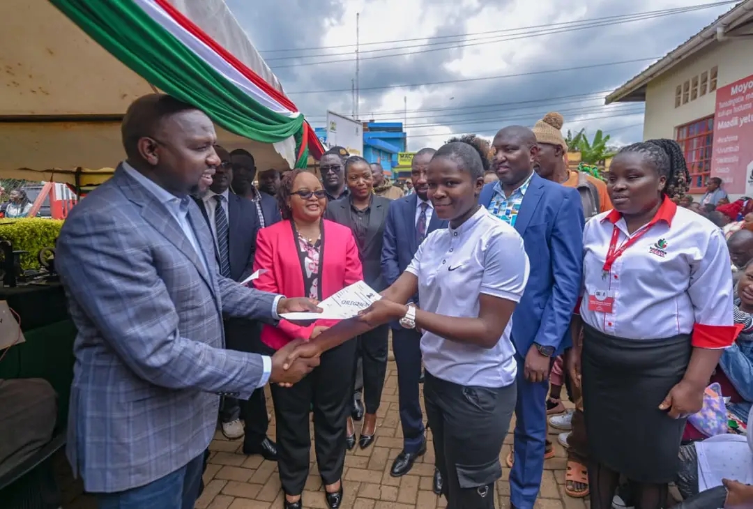 Interior CS Kipchumba Murkomen (in cap) hands over a modern carwash machine to members of Highway Jikuzee Carwash, Kerugoya, alongside Governor Anne Waiguru.