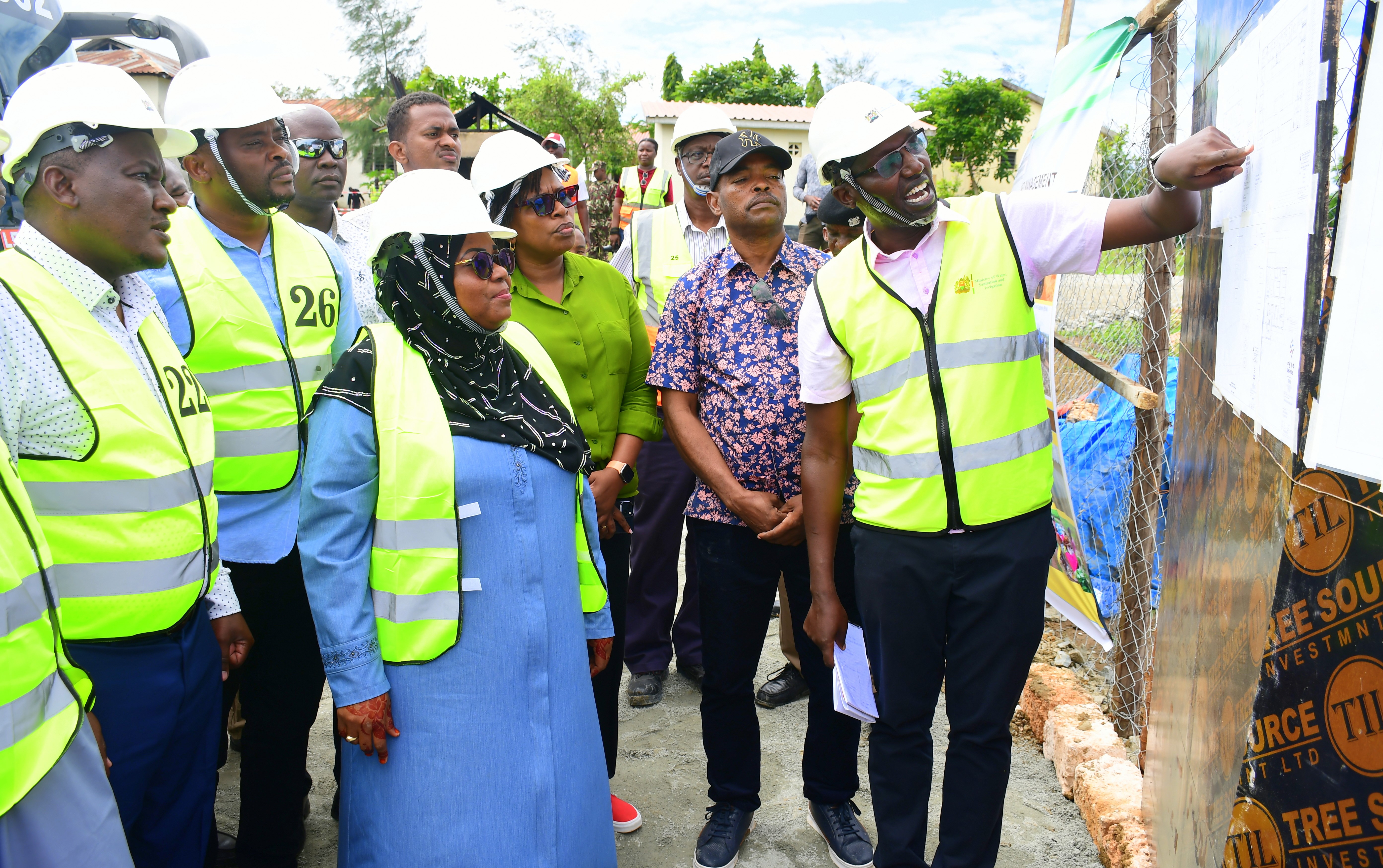 Principal Secretary (PS) State Department for Irrigation CPA Ephantus Kimotho (L), Kwale Governor Fatuma Achani (Black headscarf) flanked by County and Ministry officials, are taken through sketches of a new dispensary under construction in Kinango Sub-County, Kwale. 