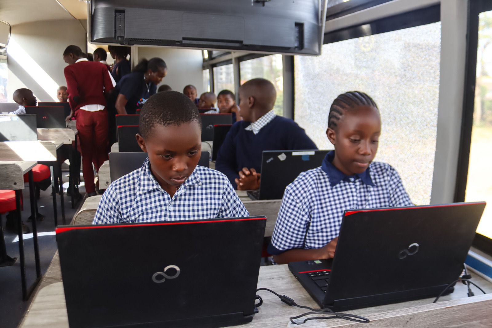 A student participates in a digital learning session aboard the Digi-AI Bus, a mobile classroom designed to deliver coding, AI and digital literacy skills to learners from underserved communities at the RFUEA Grounds