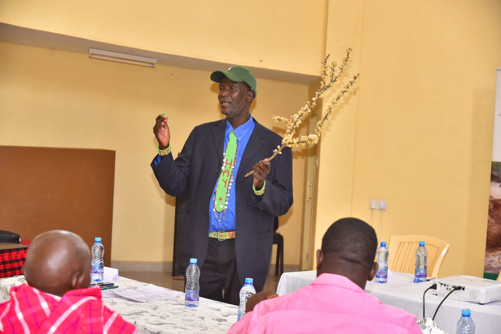 Mzee John ole Wuapari, one of the traditional experts on weather forecasting explains how they forecast the weather using the flowering of plants. Photo/Diana Meneto.