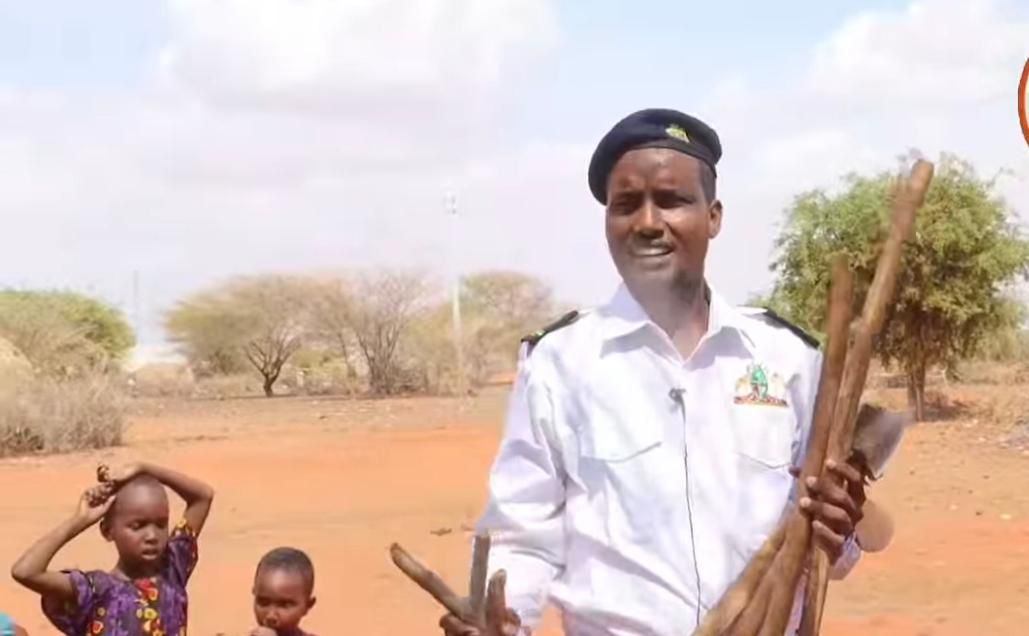 Wagalla Ward Administrator, a member of the Rangeland Management Committee holding up a handful of surrendered axes and pangas