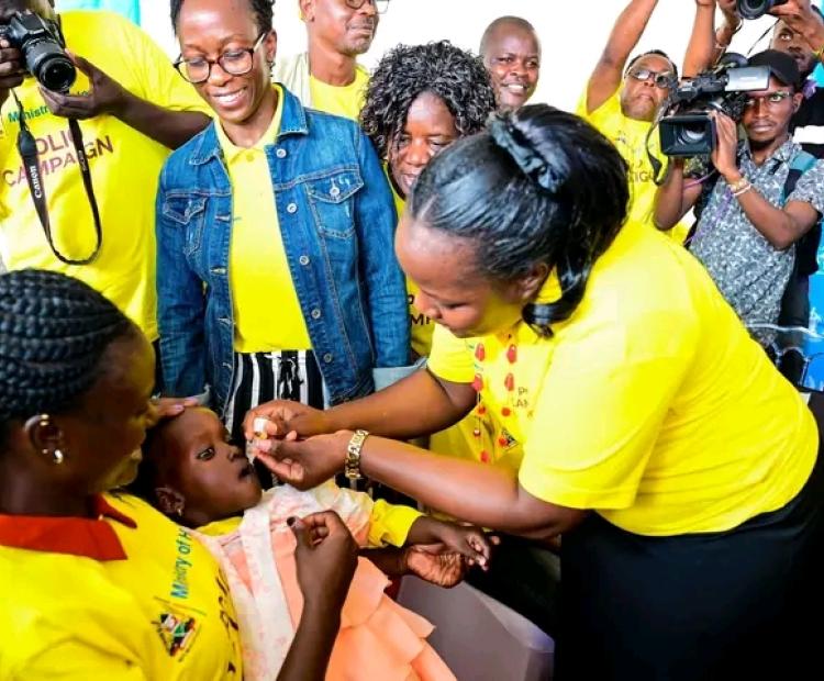 1727976470015.jpg:- Bungoma County Health and Sanitation CECM Madam Carolyne Makali administering a polio dose to a child below five years at Lwakhakha border point. Photo/