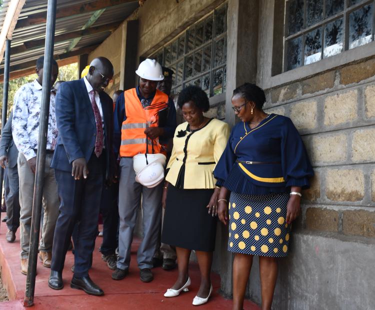 Principal Secretary, State Department for Basic Education, Dr. Belio Kipsang (left) at Sulgwita primary in Turi, Molo sub-county to inspect the construction progress of grade nine classes.