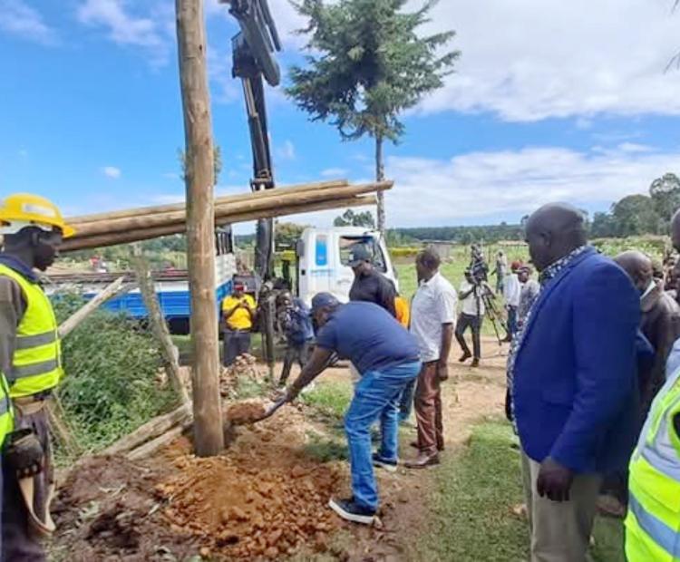 Principal Secretary in the State Department for Energy Alex Wachira (in jeans) installs a power pole in Gikamba sub-location Kieni Nyeri county where a total of 314 homes were connected with electricity.