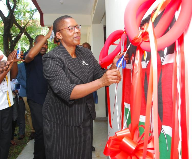 Attorney General Dorcas Oduor cuts the tape as she officially opens a regional documentation resource centre in Kisumu.