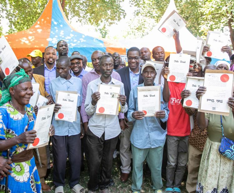 Residents of Nyagwethe display their acquired land title deeds. 