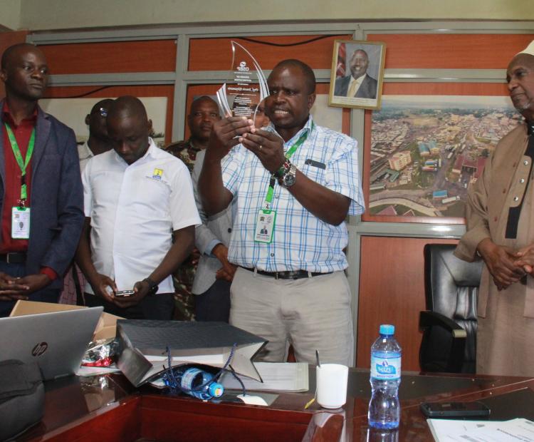 National Biosafety Authority Ag. CEO Nehemiah Ngetich displaying a gift awarded to the Authority by Kenya Revenue Authority for their good service