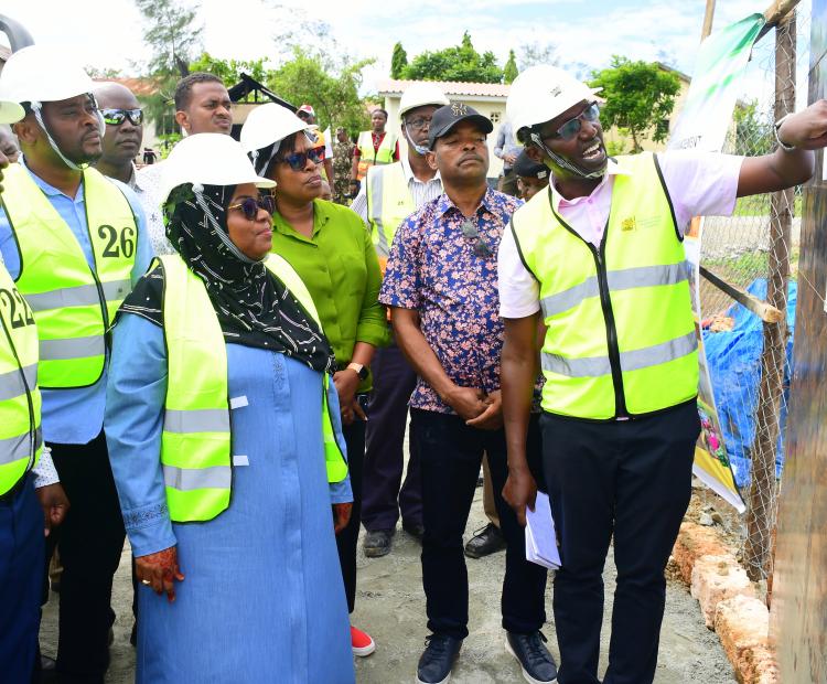 Principal Secretary (PS) State Department for Irrigation CPA Ephantus Kimotho (L), Kwale Governor Fatuma Achani (Black headscarf) flanked by County and Ministry officials, are taken through sketches of a new dispensary under construction in Kinango Sub-County, Kwale. 