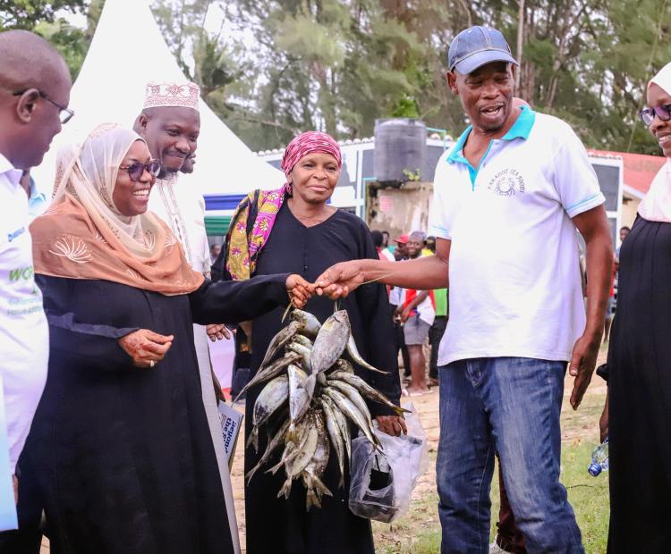 Kwale Governor Fatuma Achani (2nd L) admires fish caught by local fishermen in Msambweni sub county during the distribution of essential fishing equipment to local fisherfolk