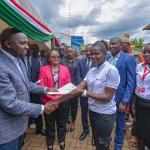 Interior CS Kipchumba Murkomen (in cap) hands over a modern carwash machine to members of Highway Jikuzee Carwash, Kerugoya, alongside Governor Anne Waiguru.
